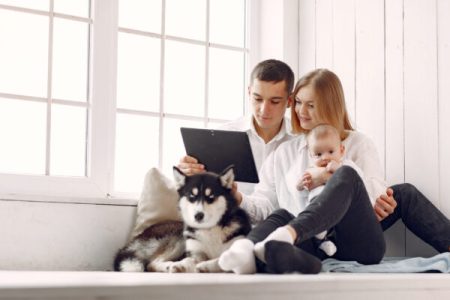 Cute family in a room. Lady in a white shirt. Family sitting with tablet.